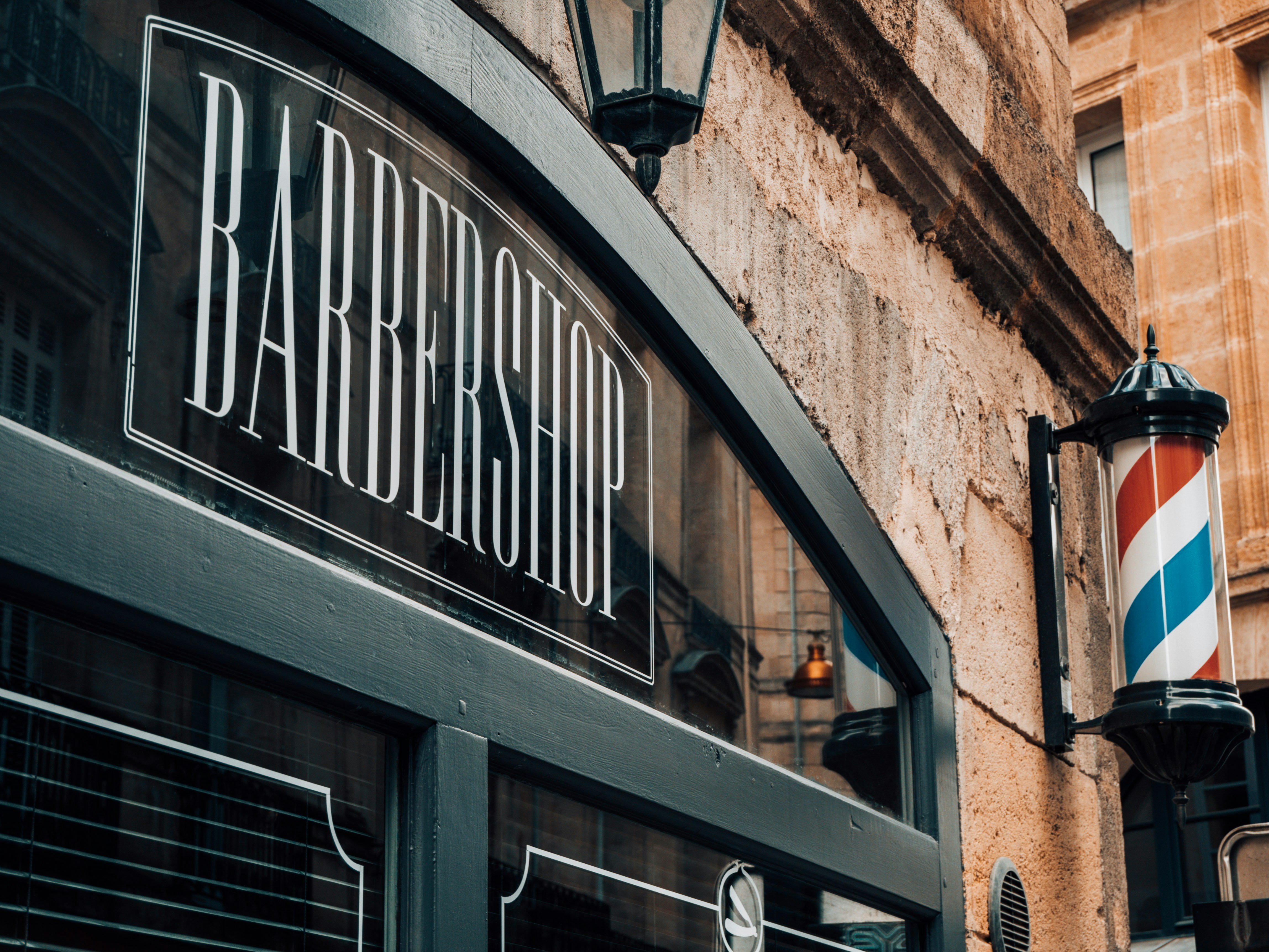 Klassische Barbershop-Fassade mit Schriftzug und Barber-Säule