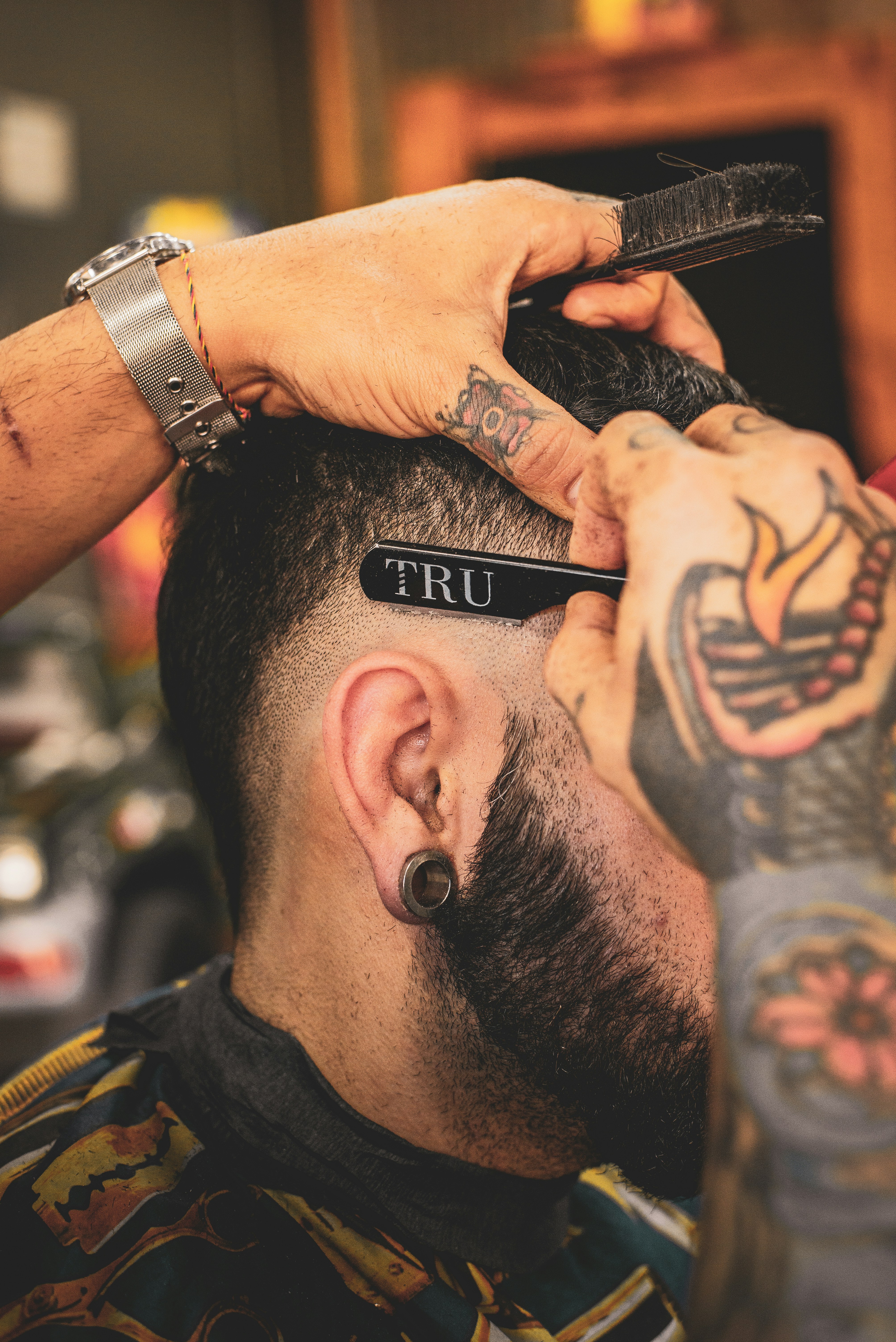 Barbier zieht mit dem Rasiermesser eine saubere Kontur am Nacken